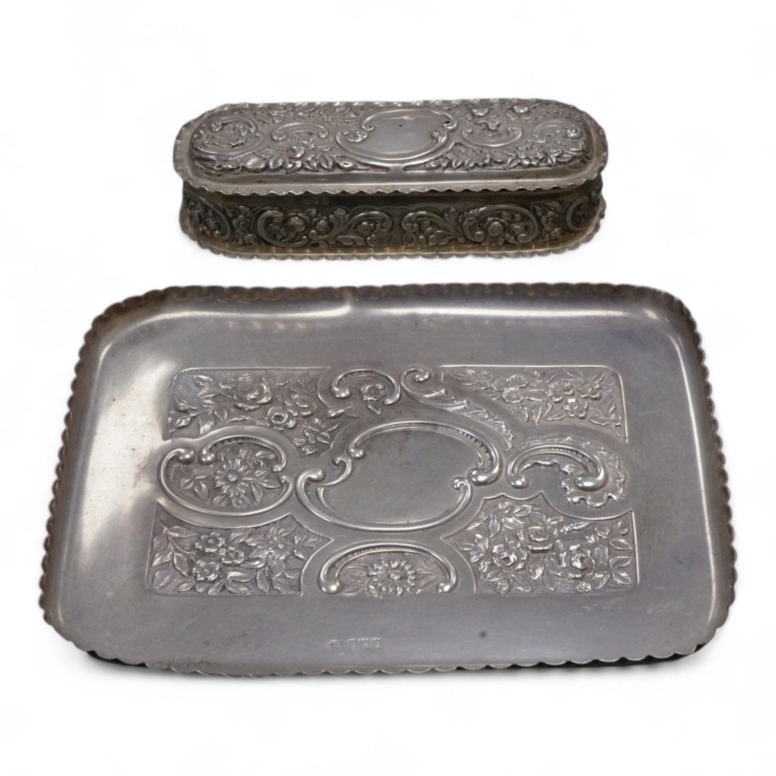 An early 20th century repousse silver dressing table tray by William Comyns & Sons Ltd, London, 1901, 25.1cm, together with a matching oval trinket box, London, 1900, 16.6oz (a.f.).